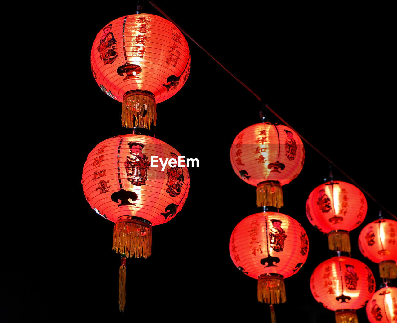 LOW ANGLE VIEW OF ILLUMINATED LANTERN HANGING AT NIGHT