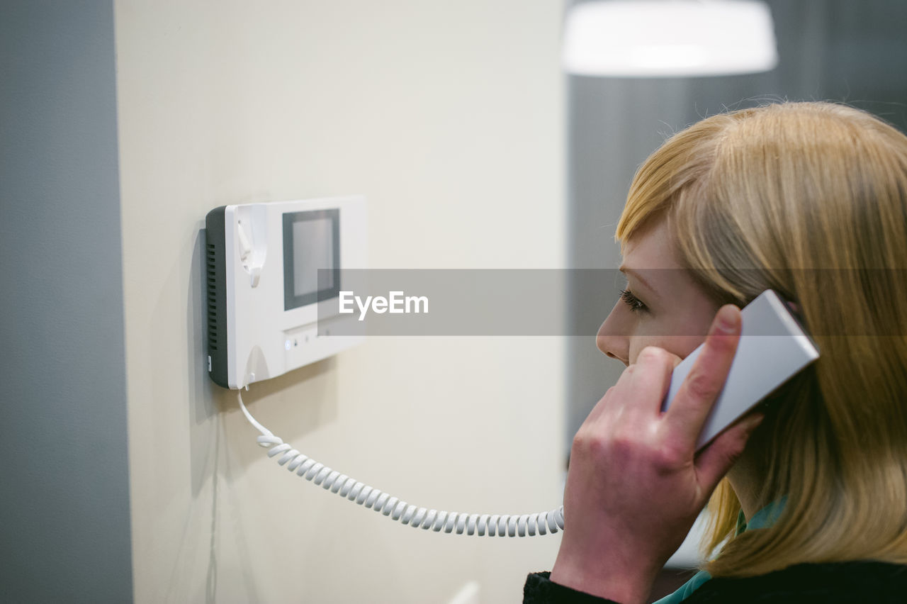 Close-up of young woman talking on phone at home