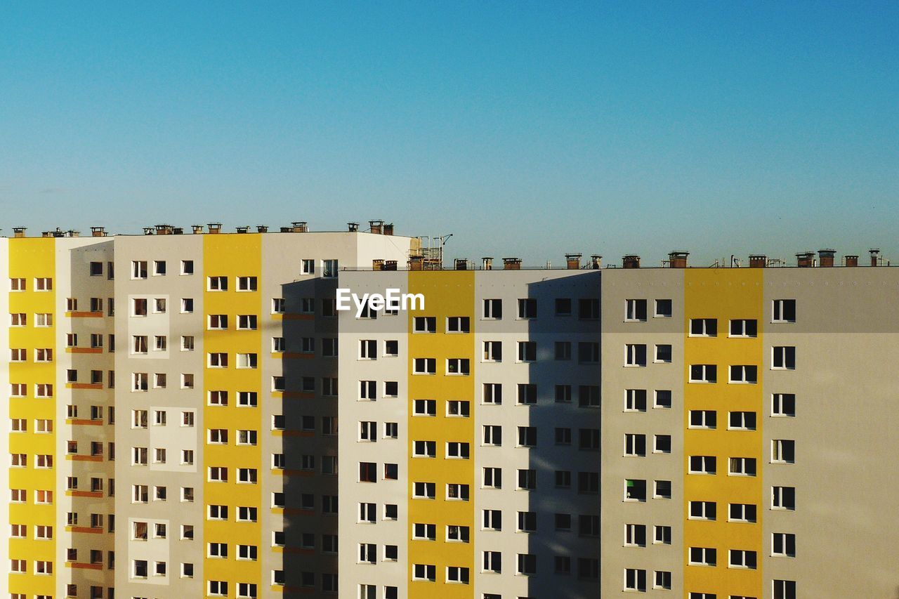 Low angle view of residential buildings against clear blue sky