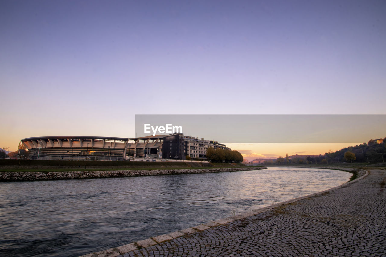 sky, architecture, dusk, sea, sunset, horizon, evening, water, reflection, built structure, coast, shore, nature, city, beach, building exterior, travel destinations, ocean, body of water, land, clear sky, travel, no people, building, blue, outdoors, scenics - nature, tourism, landscape, bay, environment, sunlight, cloud, beauty in nature, copy space, history, tranquility, cityscape, wave, the past
