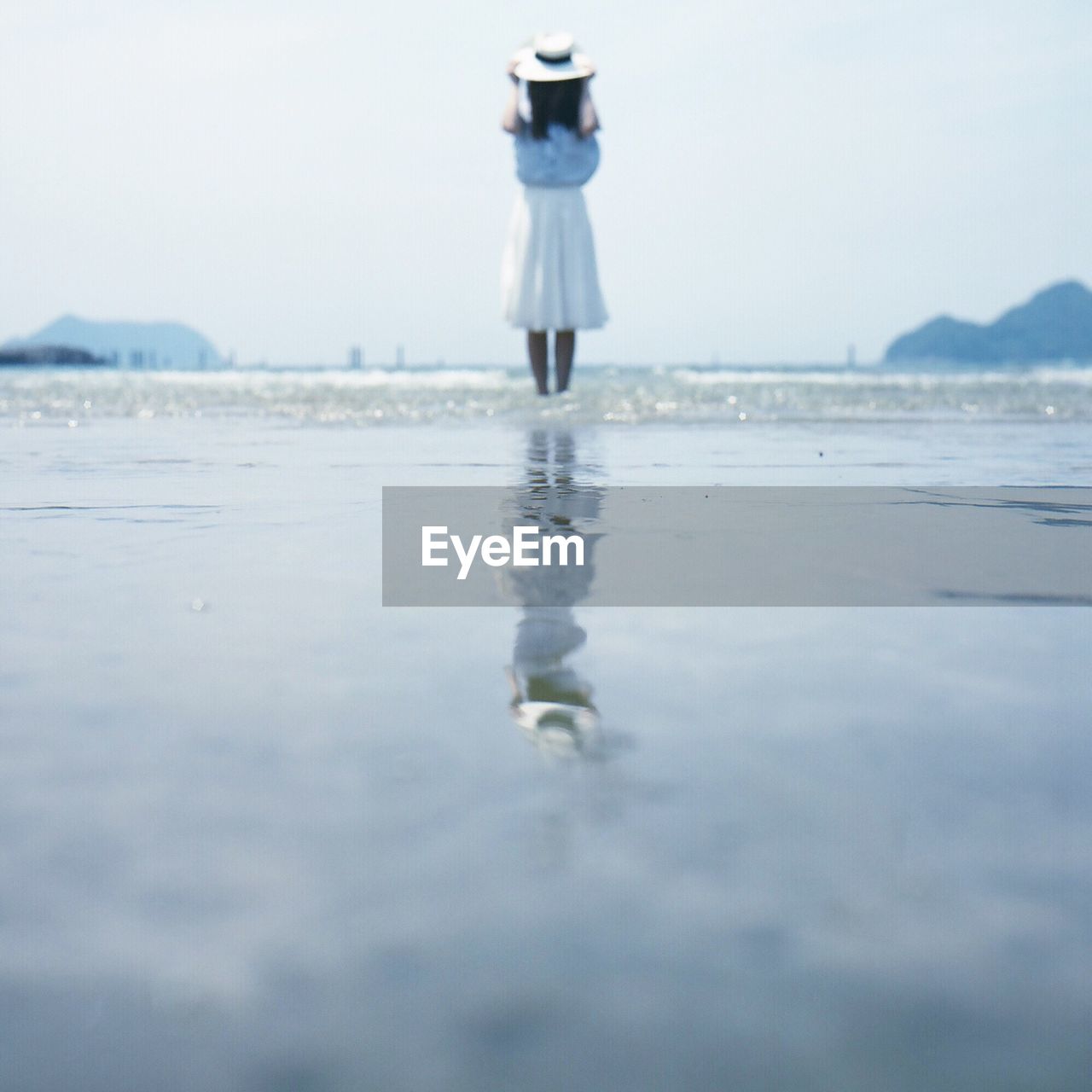 Rear view of girl standing at beach