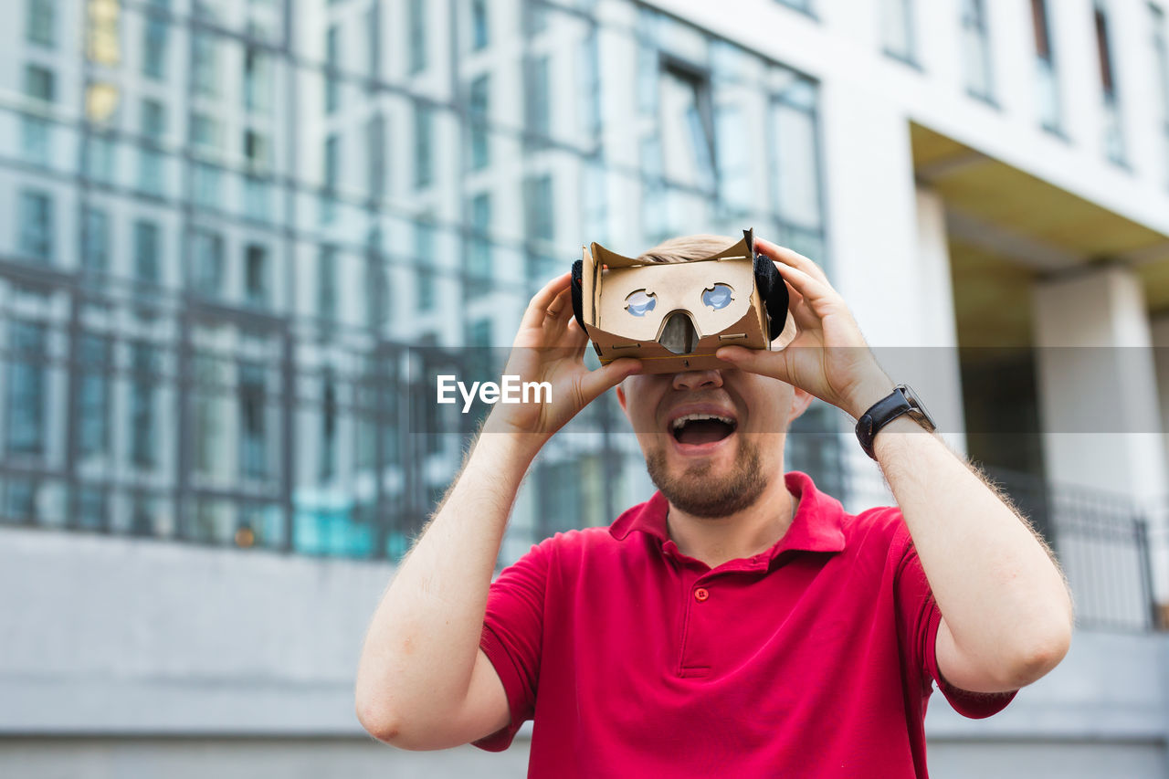 Man wearing virtual reality headset while standing outdoors