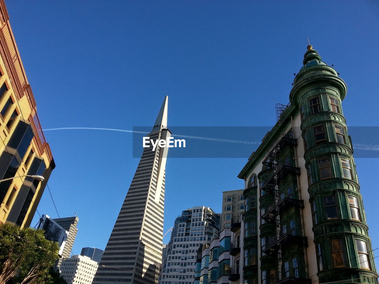 Low angle view of skyscrapers against blue sky