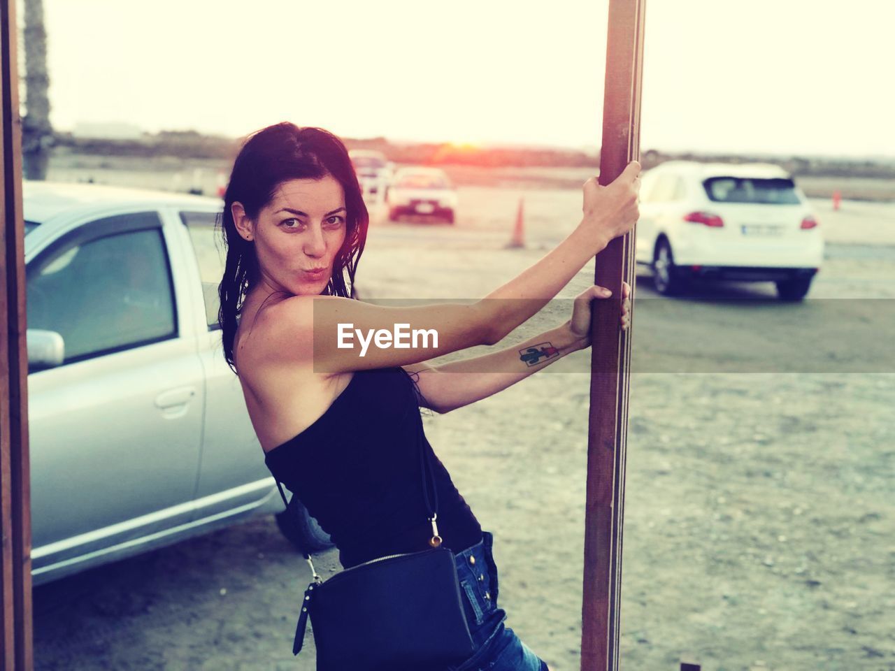 Portrait of smiling woman standing by car