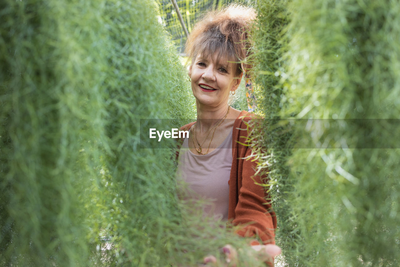 portrait of woman standing amidst plants