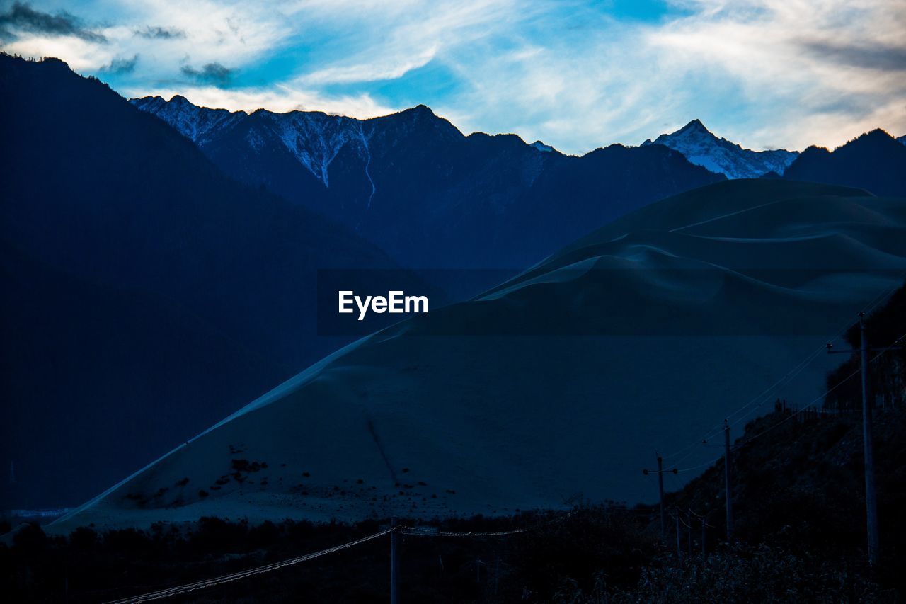 Scenic view of mountains against sky at dusk