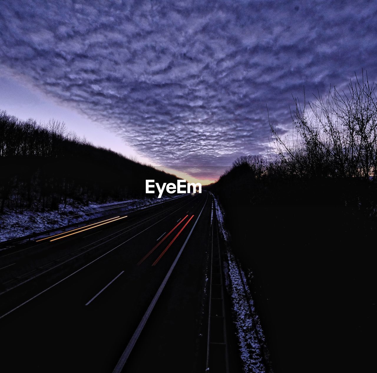 LIGHT TRAILS ON BRIDGE AT NIGHT