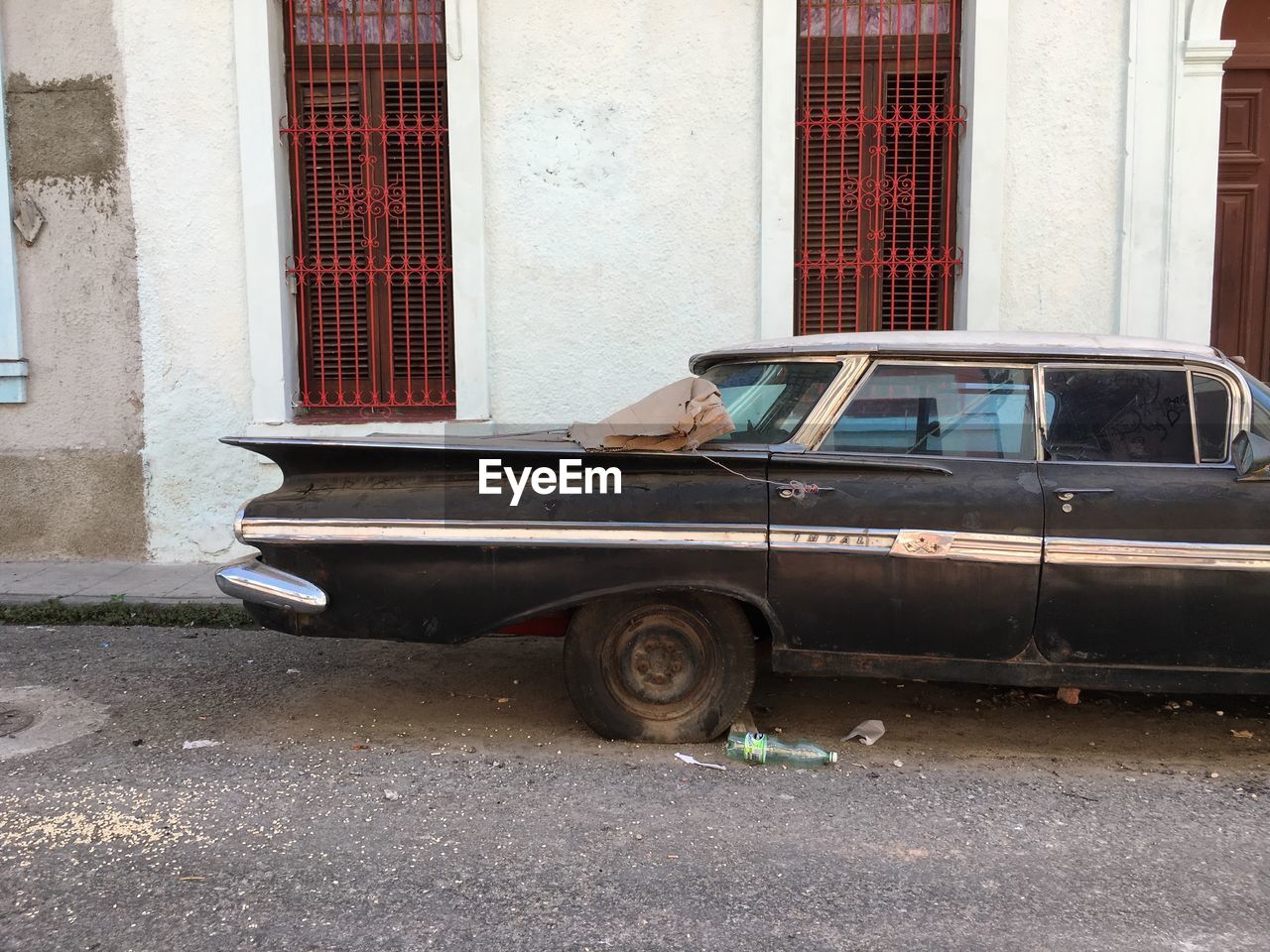 ABANDONED CAR ON STREET BY BUILDING