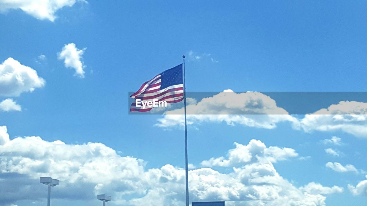 LOW ANGLE VIEW OF AMERICAN FLAG AGAINST SKY