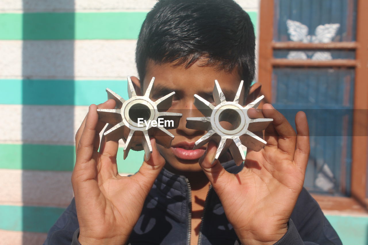 CLOSE-UP PORTRAIT OF BOY HOLDING CAMERA