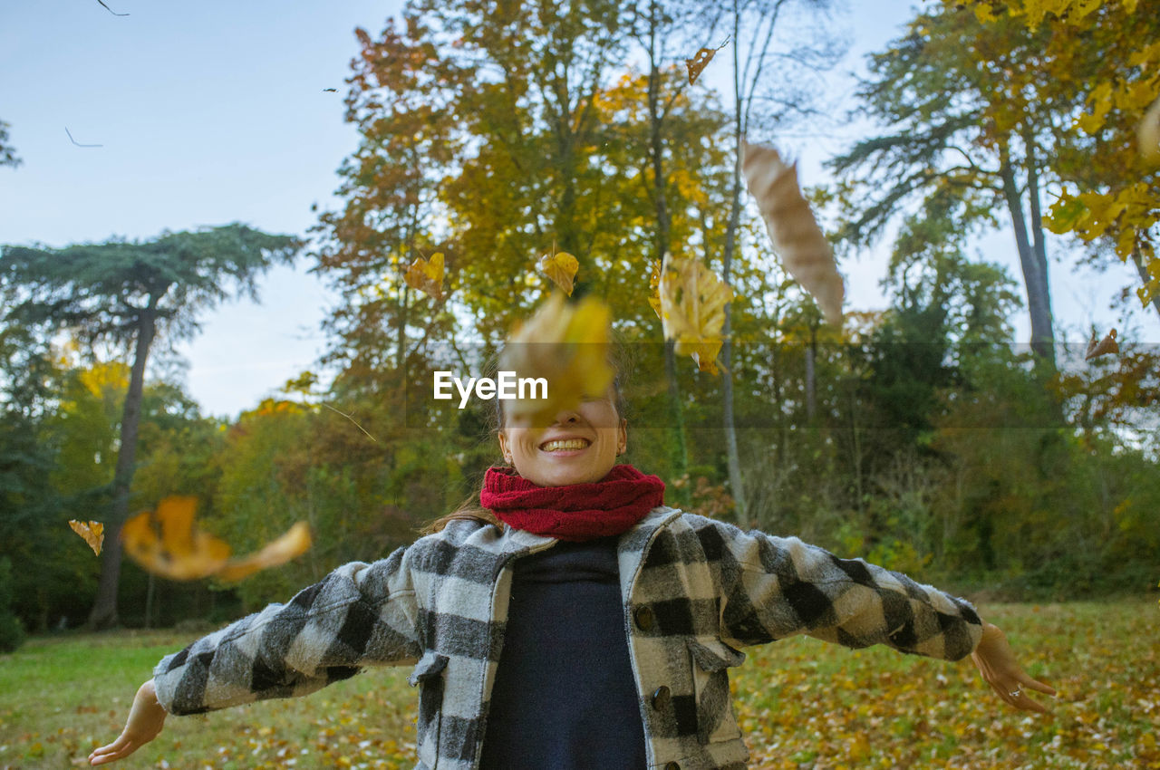 Portrait of smiling woman against trees