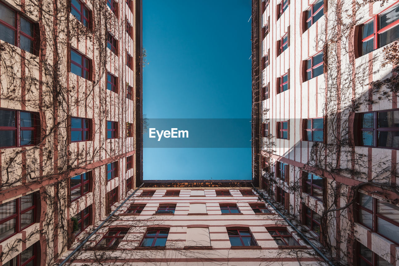 Low angle view of buildings against clear blue sky