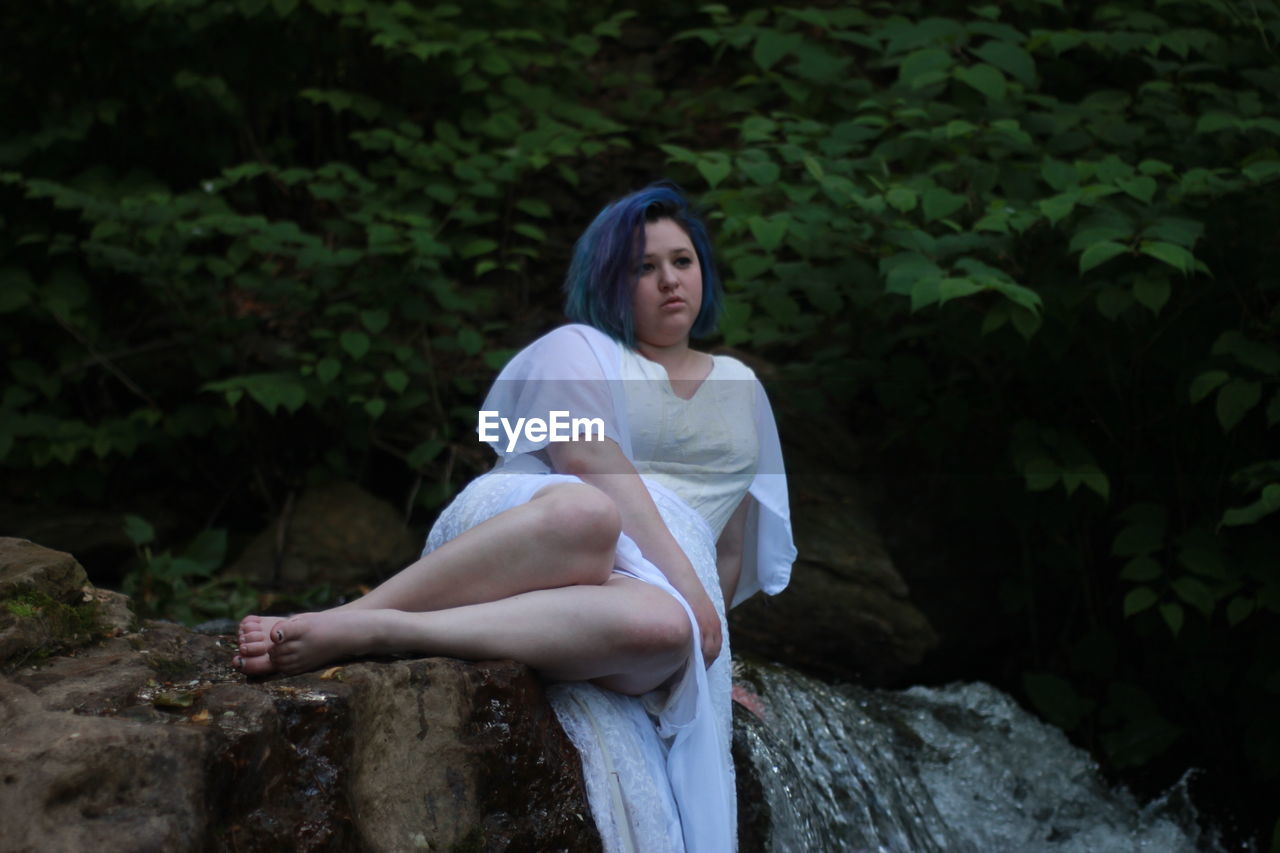 Young woman looking away in forest