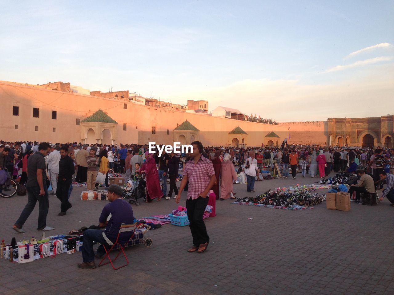 People at market by bab mansour against sky