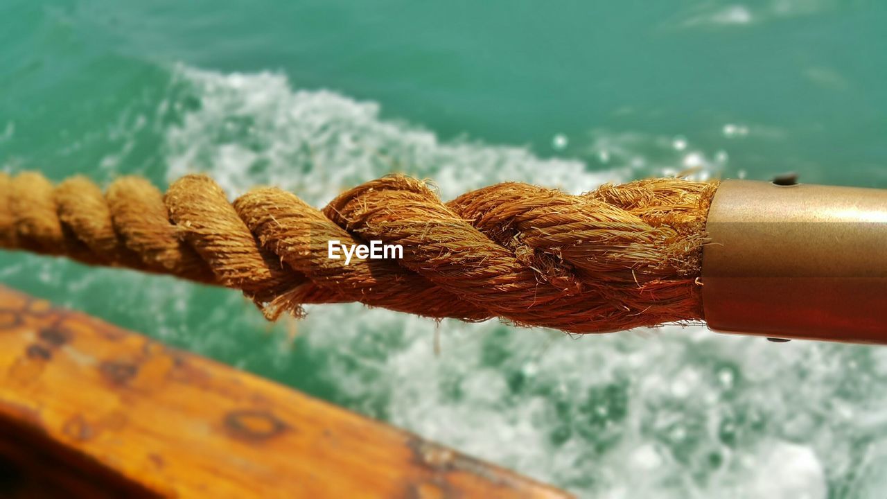 CLOSE-UP OF ROPE TIED UP ON METAL