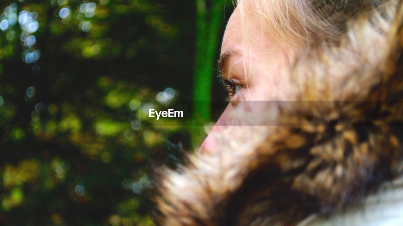 Close-up of thoughtful woman wearing fur coat