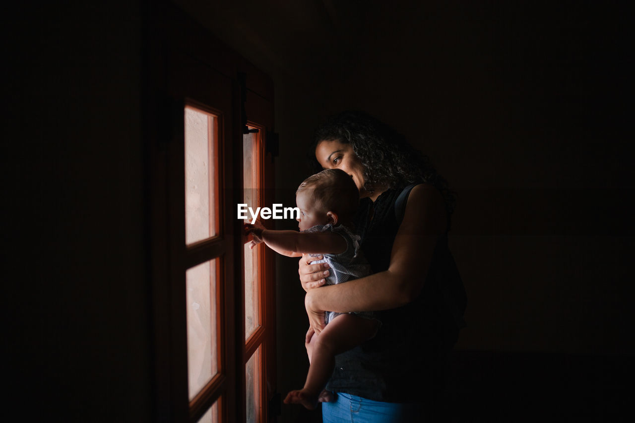 Mother with son looking through window