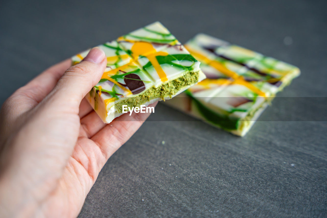 cropped hand of person holding paper currency on table