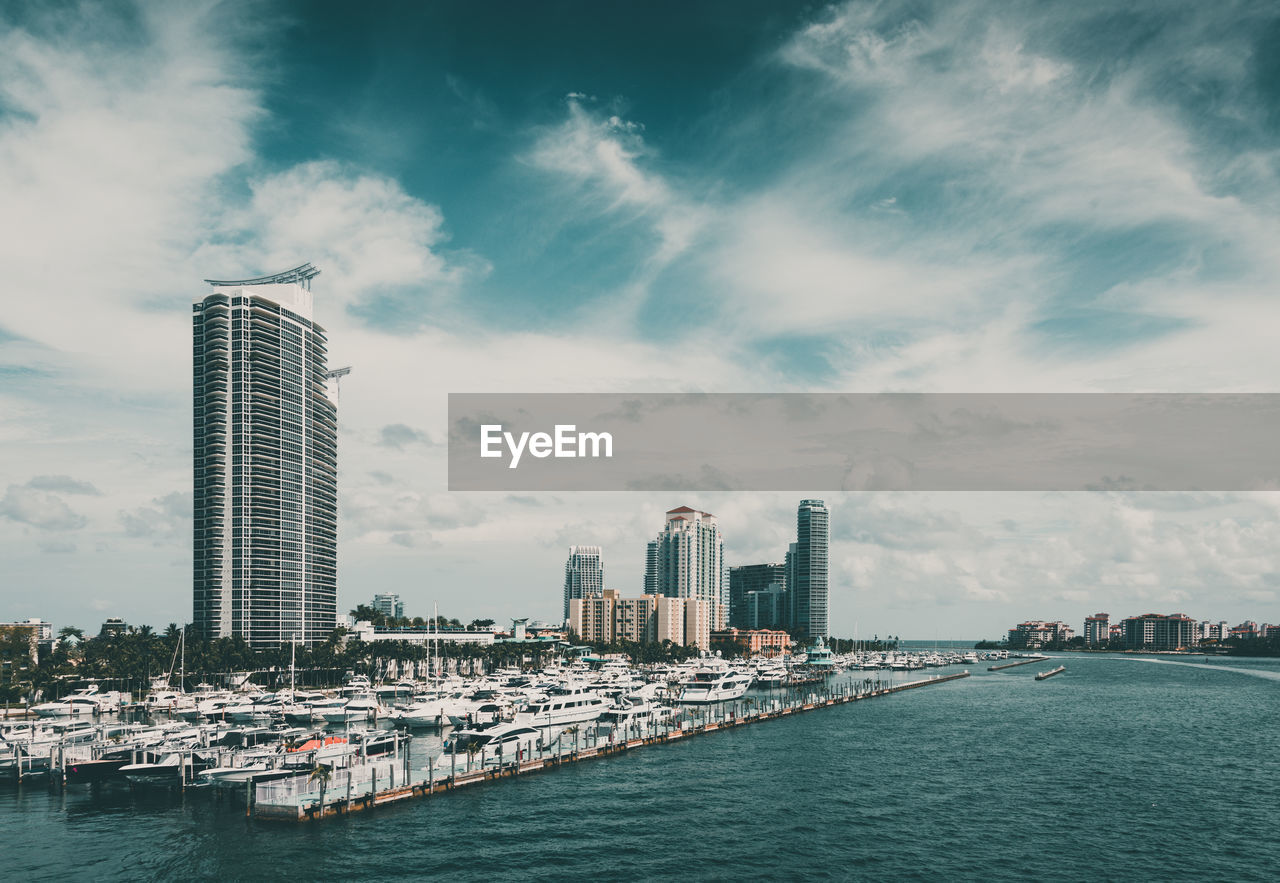 Modern buildings by sea against sky