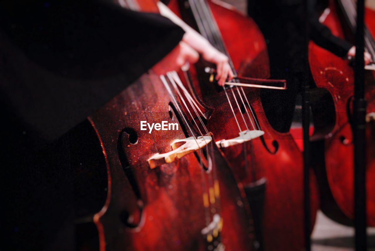 Cropped image of musician playing cellos