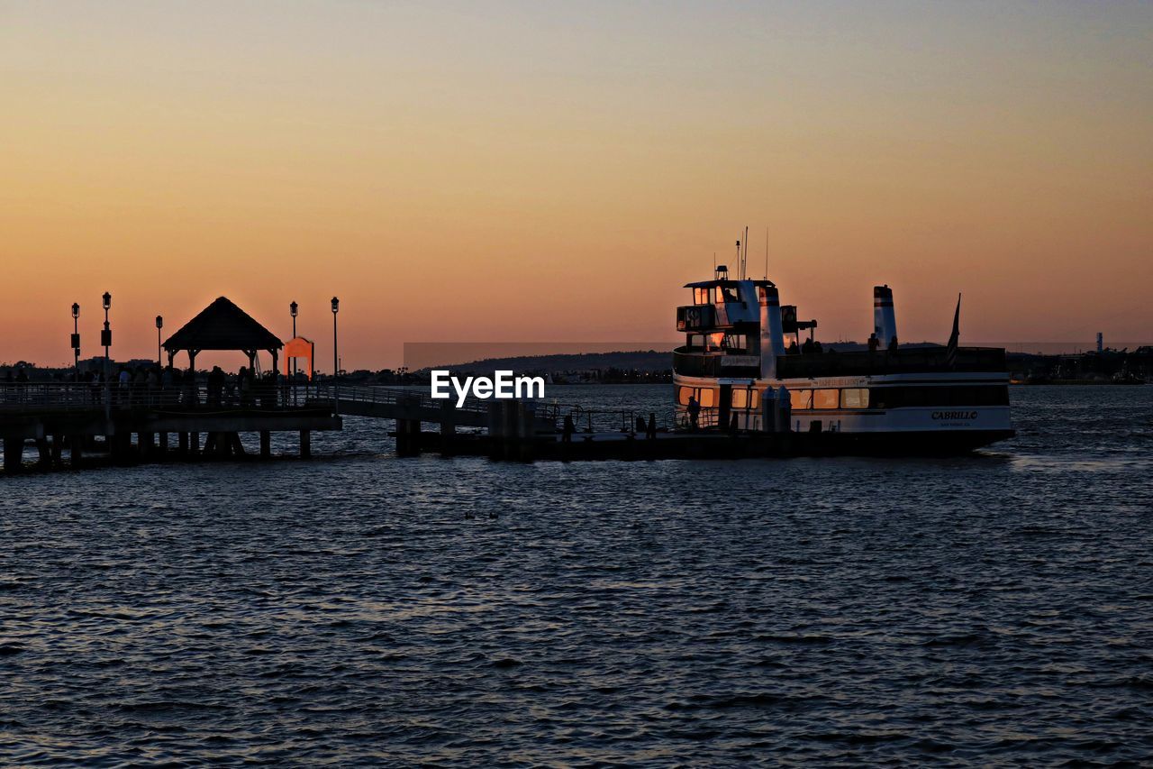 Boats in sea at sunset