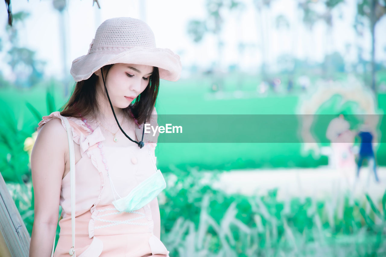 Young woman wearing hat standing outdoors