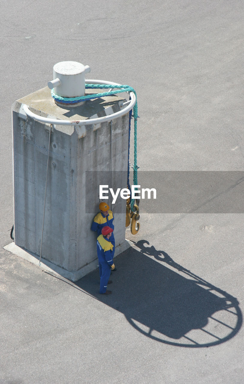 HIGH ANGLE VIEW OF MAN WORKING WITH UMBRELLA