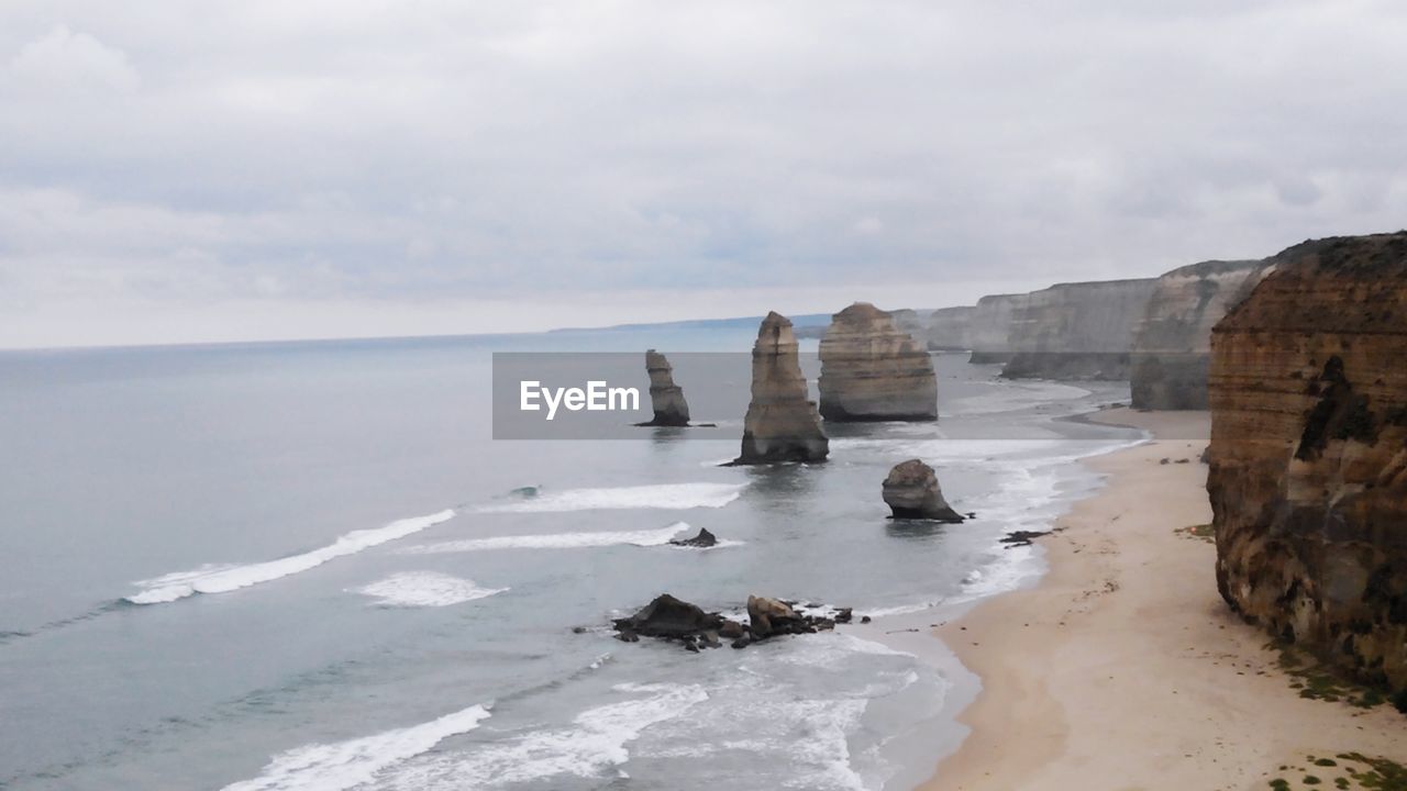 SCENIC VIEW OF ROCKS ON BEACH AGAINST SKY