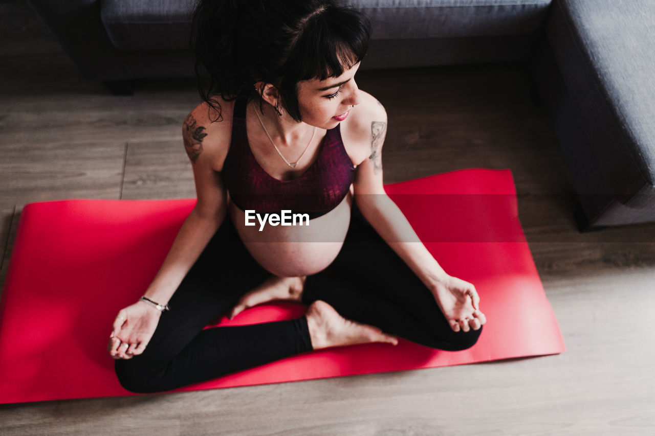 Pregnant woman exercising while sitting at home