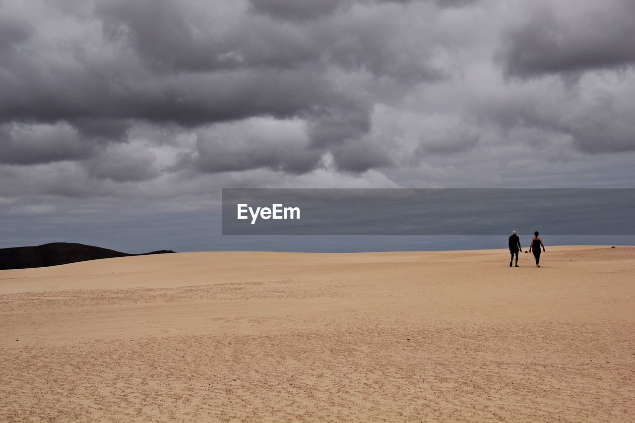 PEOPLE ON BEACH AGAINST SKY