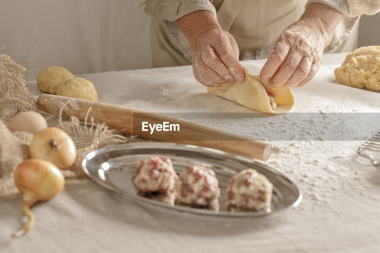 cropped hand of woman preparing food on table