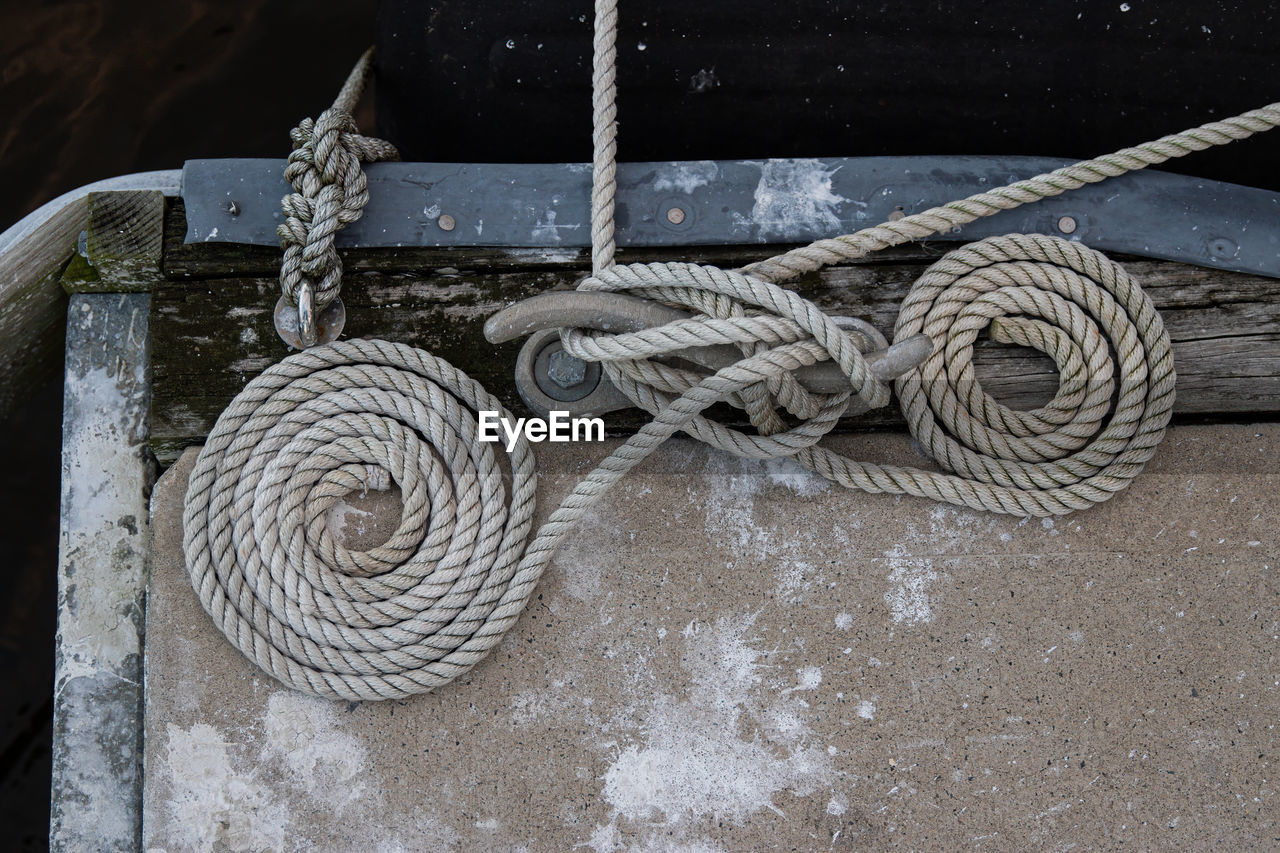 HIGH ANGLE VIEW OF ROPE TIED UP ON METAL