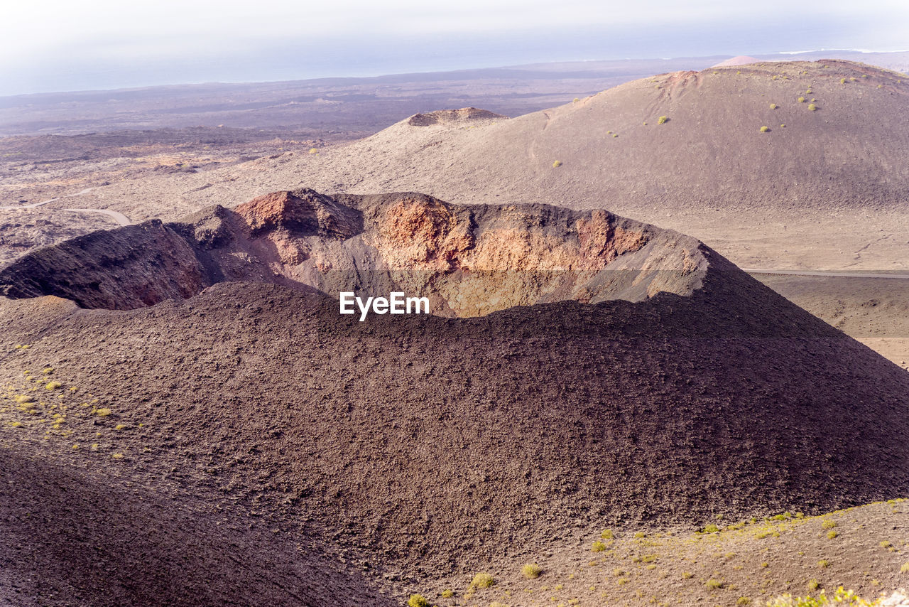 Scenic view of a volcano crater mountains against sky