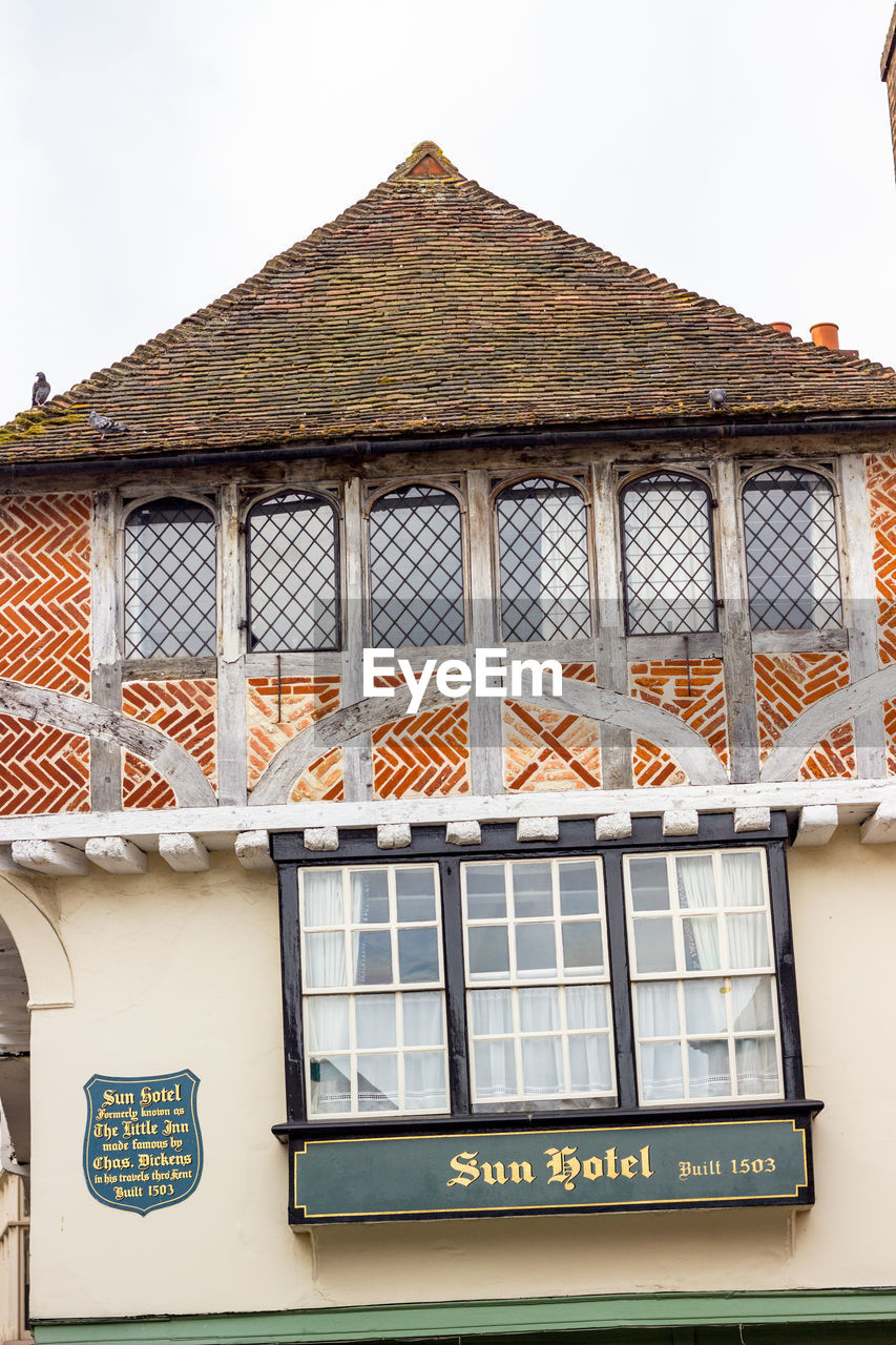 LOW ANGLE VIEW OF TEXT ON BUILDING AGAINST SKY