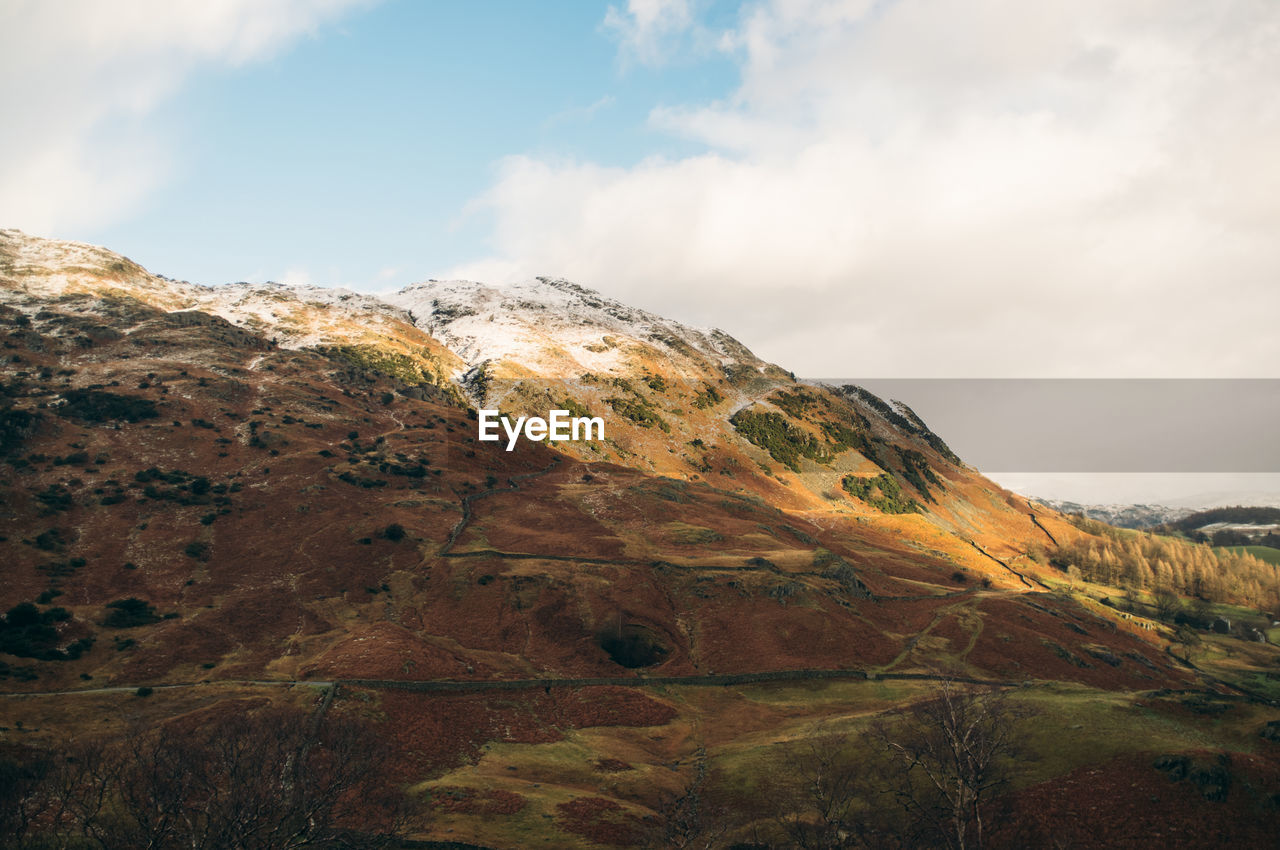 Scenic view of mountain against cloudy sky during winter