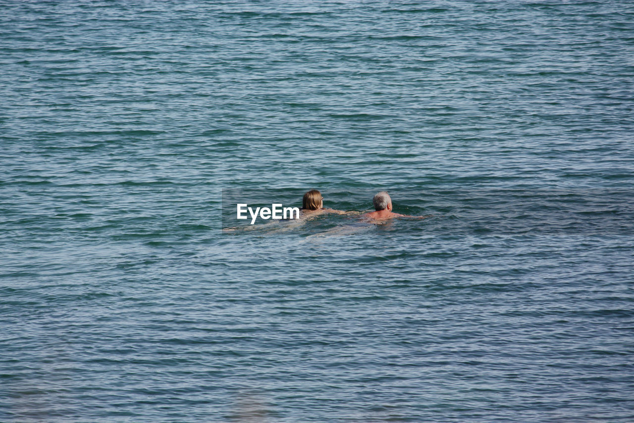 Mid distance of couple swimming in sea