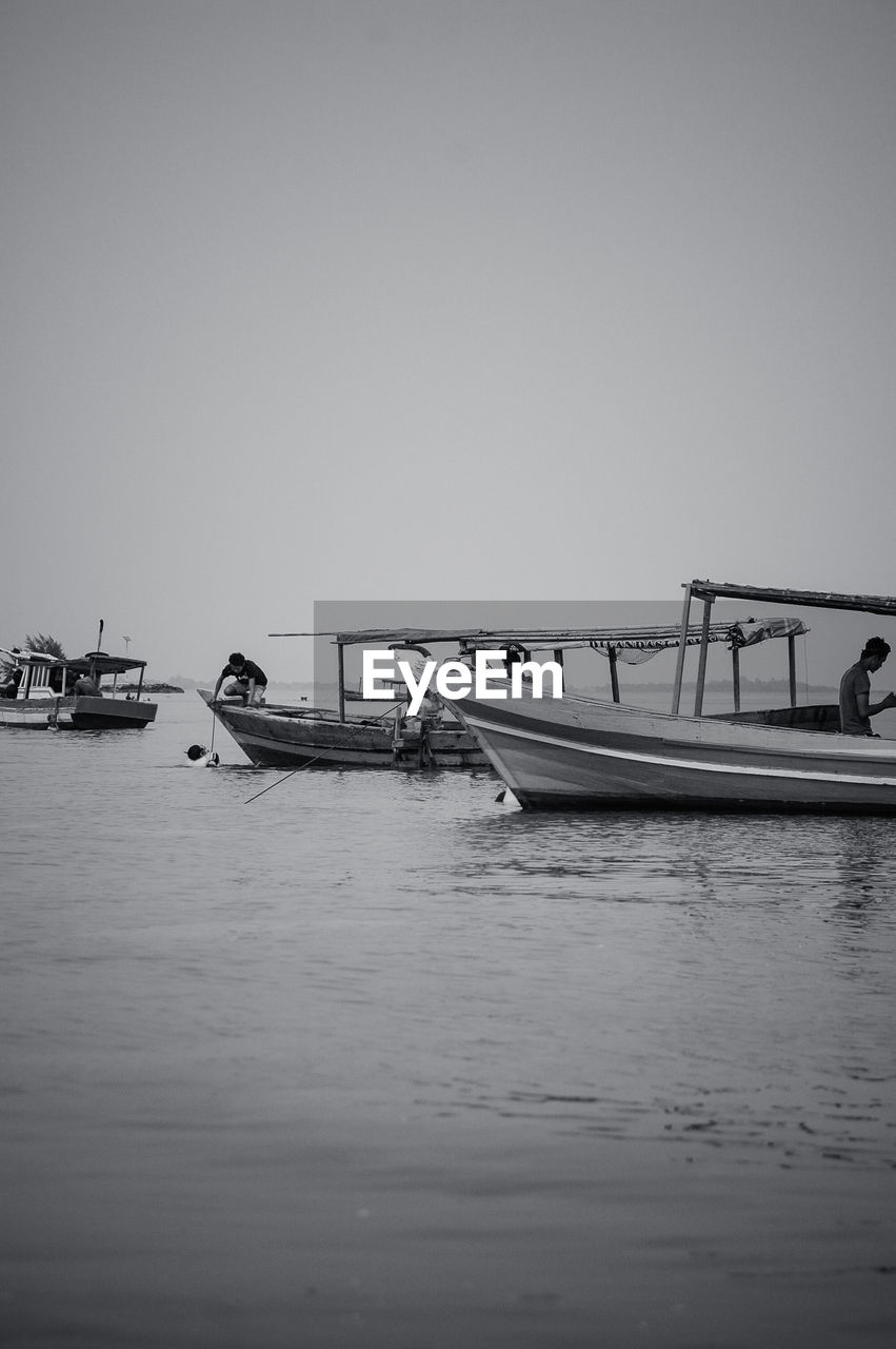 Side view of boats moored in calm sea