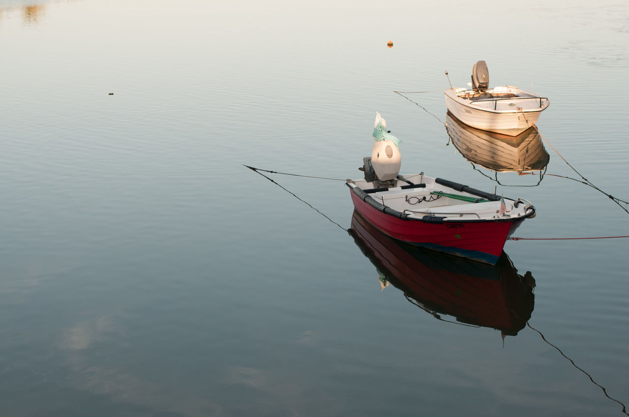 Boats moored in calm lake