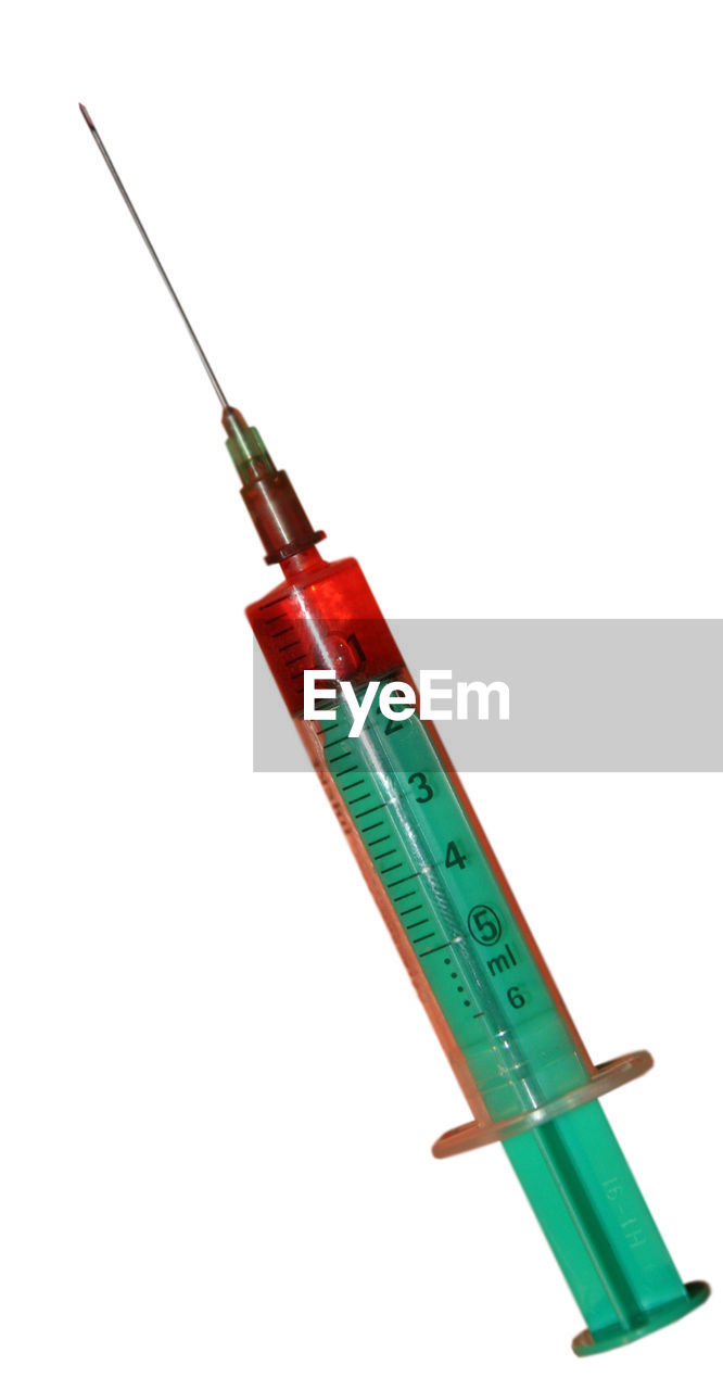 Close-up of a syringe over white background