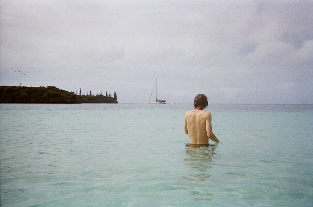 Rear view of a shirtless man in water