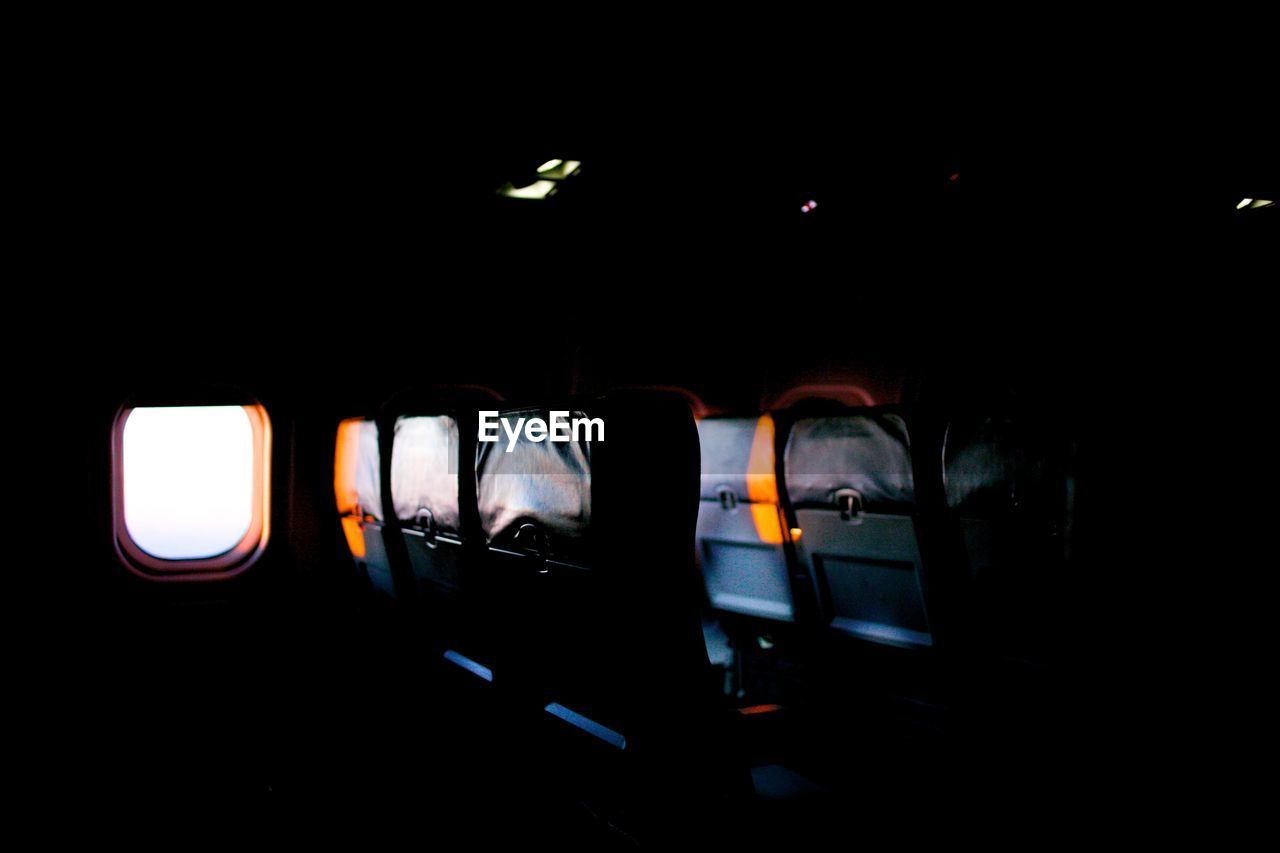 Obscure plane interior with seats and window