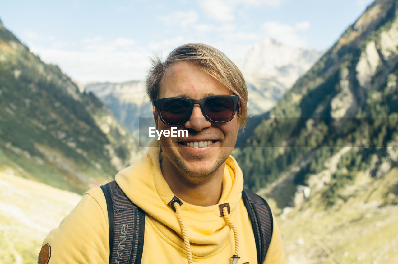 Portrait of smiling young man in mountain valley