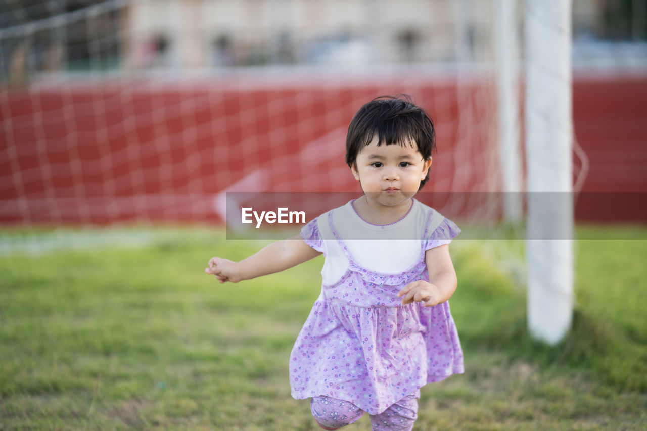 Full length of cute girl on field