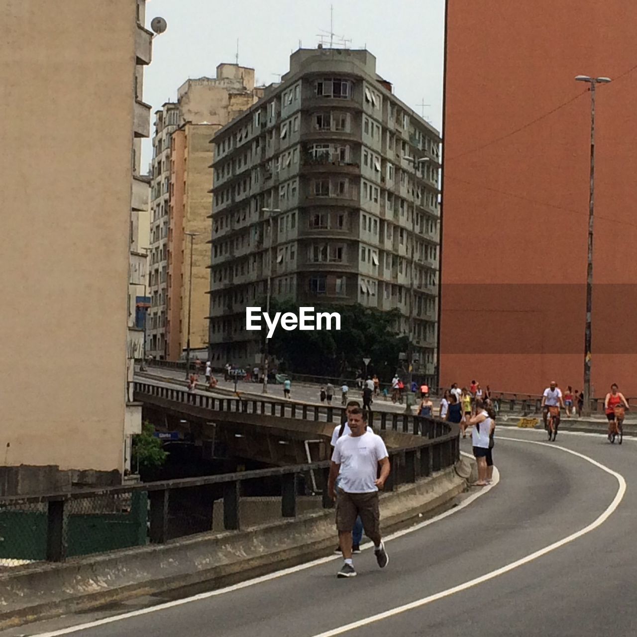 WOMAN WALKING ON ROAD IN CITY