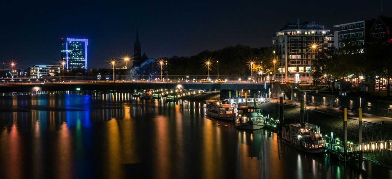 Reflection of illuminated lamp posts in calm river