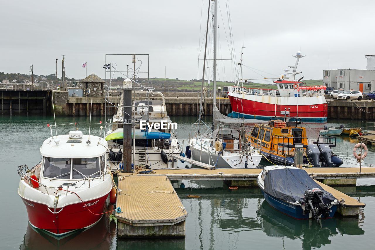 water, nautical vessel, transportation, mode of transportation, harbor, sea, moored, pier, boat, architecture, sky, nature, vehicle, port, trawler, no people, ship, travel, fishing industry, travel destinations, fishing, commercial dock, environment, watercraft, day, sailboat, waterway, dock, ferry, reflection, pole, outdoors, tugboat, built structure, marina, building exterior, tourism, landscape, overcast, beach, city, holiday, channel, mast, vacation, buoy, trip