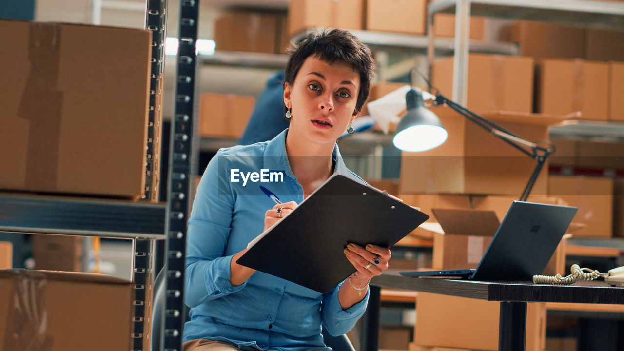 portrait of young woman standing in library