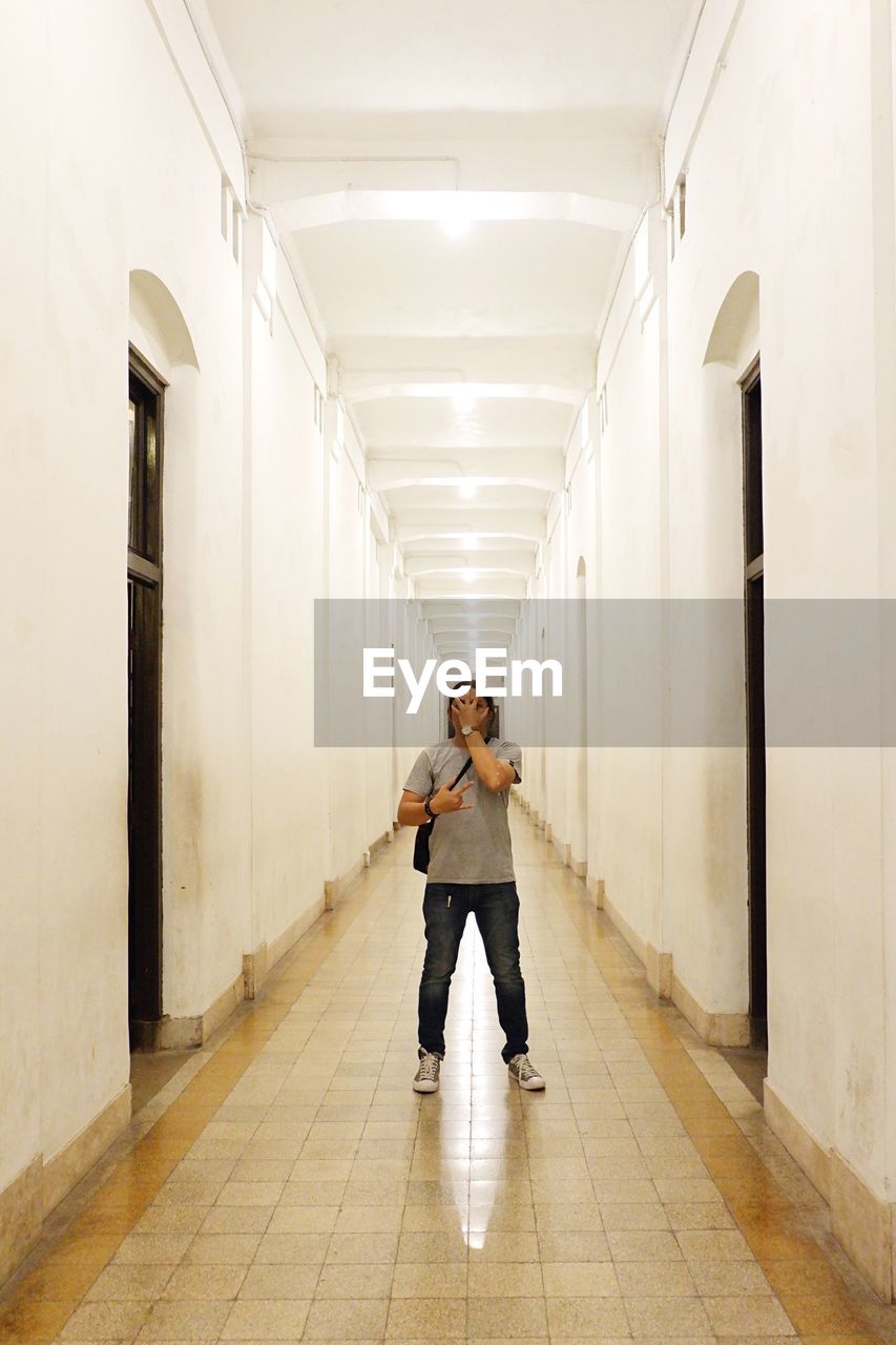 Mid adult man standing in corridor