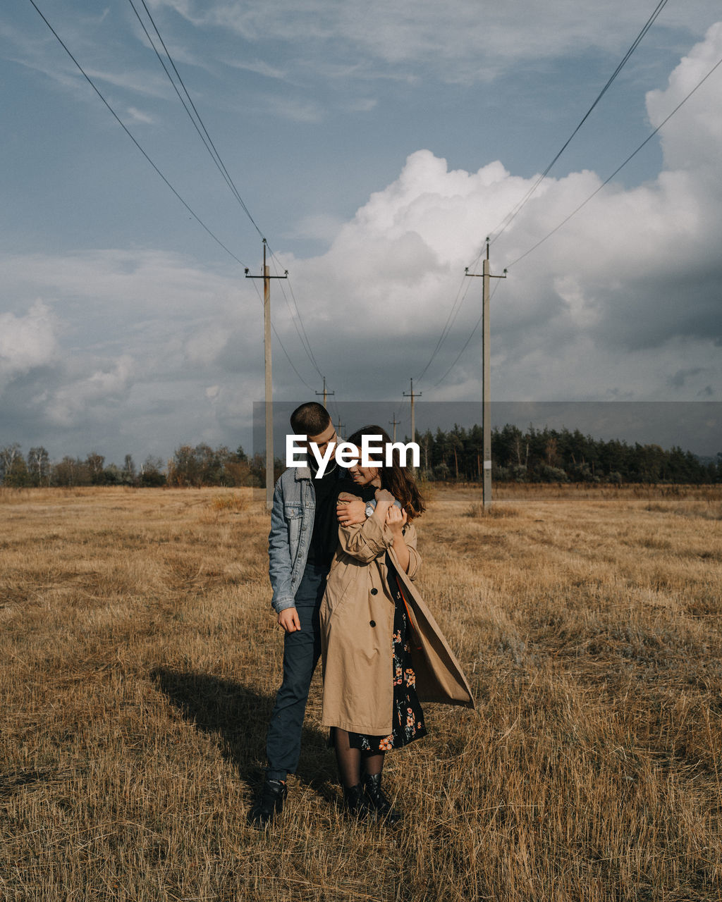 MAN AND WOMAN STANDING ON FIELD