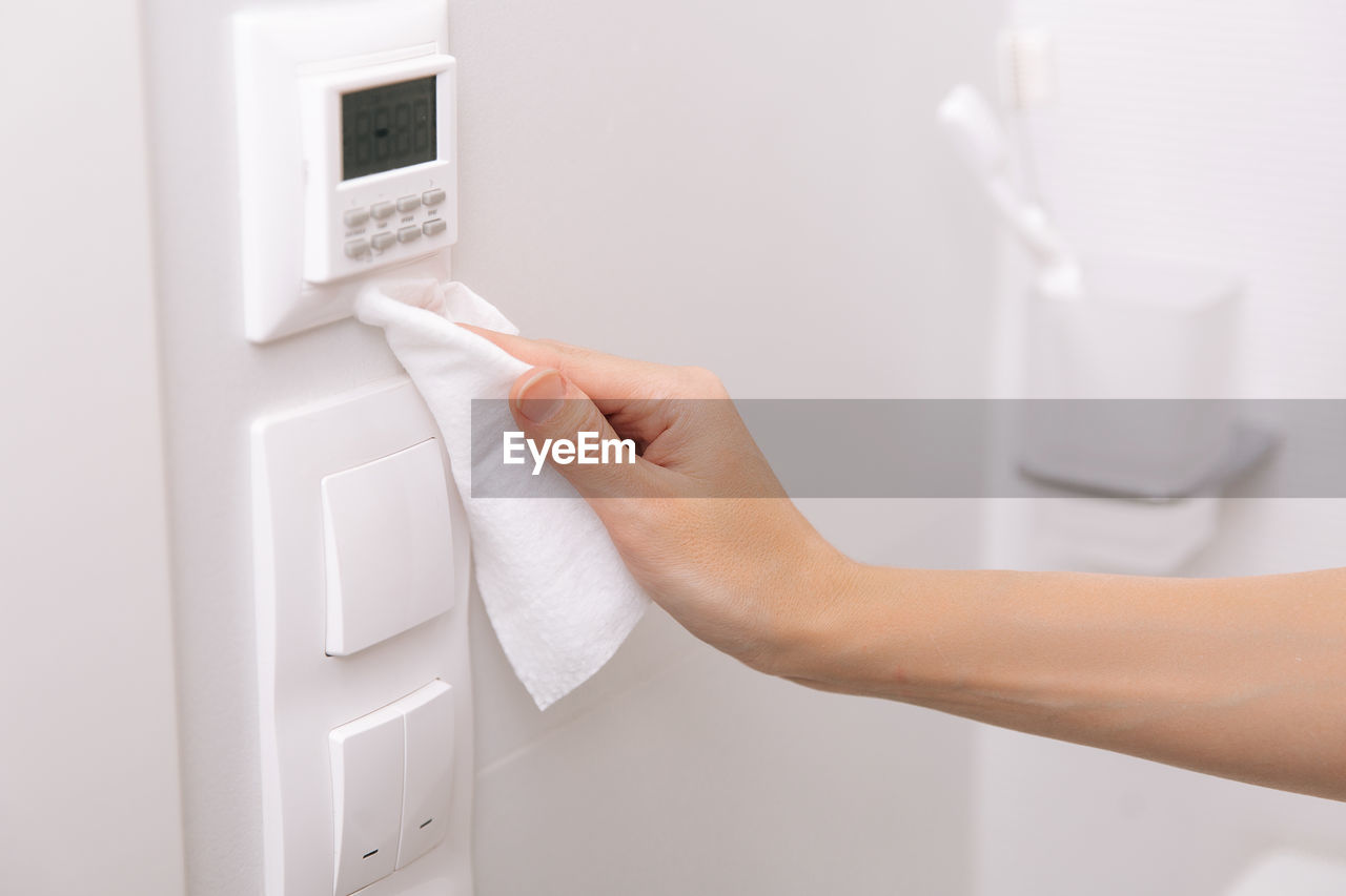 Cropped hand of person cleaning switchboard